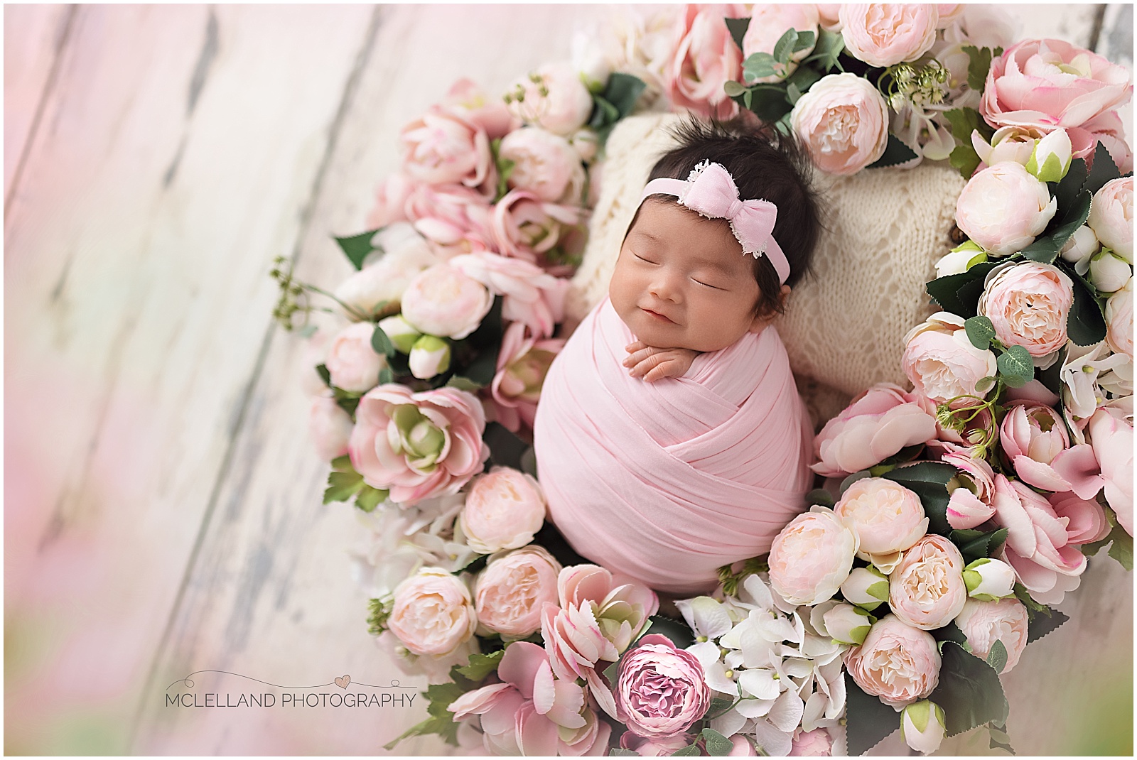 Baby girl sleeping in a wreath of flowers