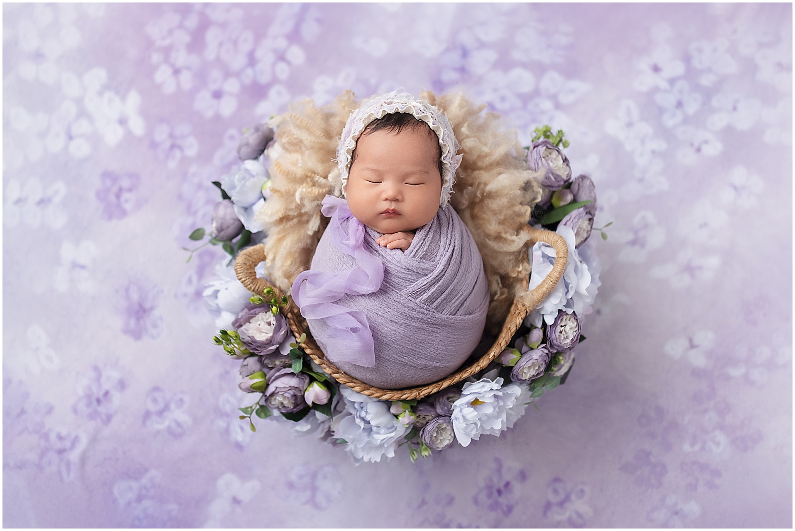 Baby girl sleeping in a purple basket