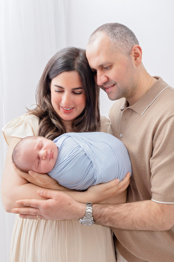 Burlington newborn photography session with parents lovingly admiring their newborn baby boy.