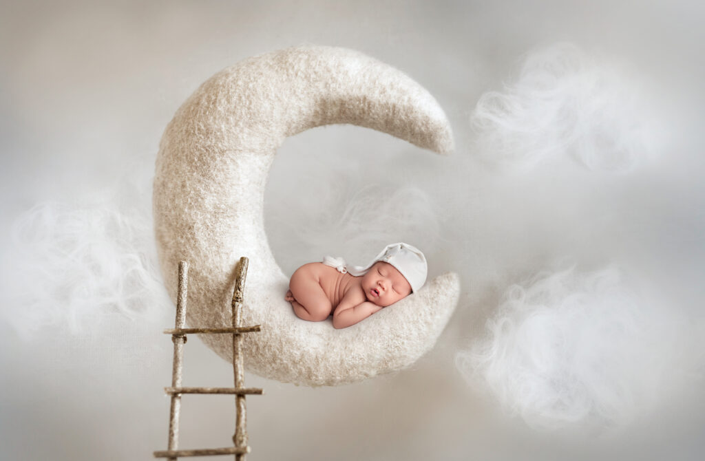 Composite newborn portrait with pillowing moon carefully planned by experienced newborn photography studios in Mississauga. 