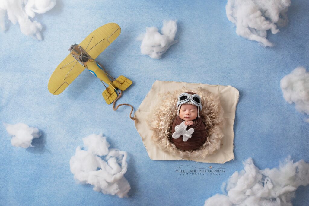 Sleeping newborn styled in an airplane setup during a baby photography Oakville studio session by McLelland Photography. 