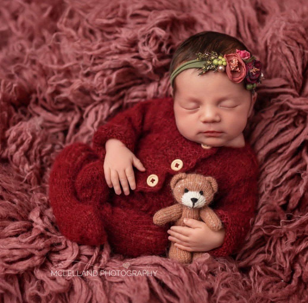 photographer capturing a sweet image of a newborn with a brown teddy bear after completing a newborn photography safety course