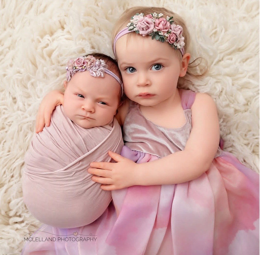 newborn baby with their sister during a photo taken at the best time for newborn photos