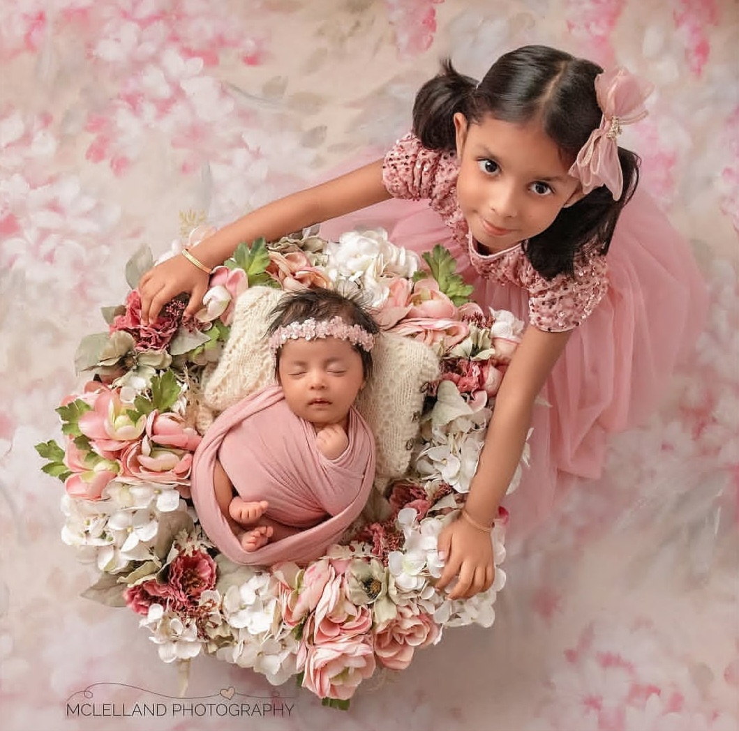 portrait of a newborn and their sister during a photoshoot because their parents knew when to schedule newborn photos