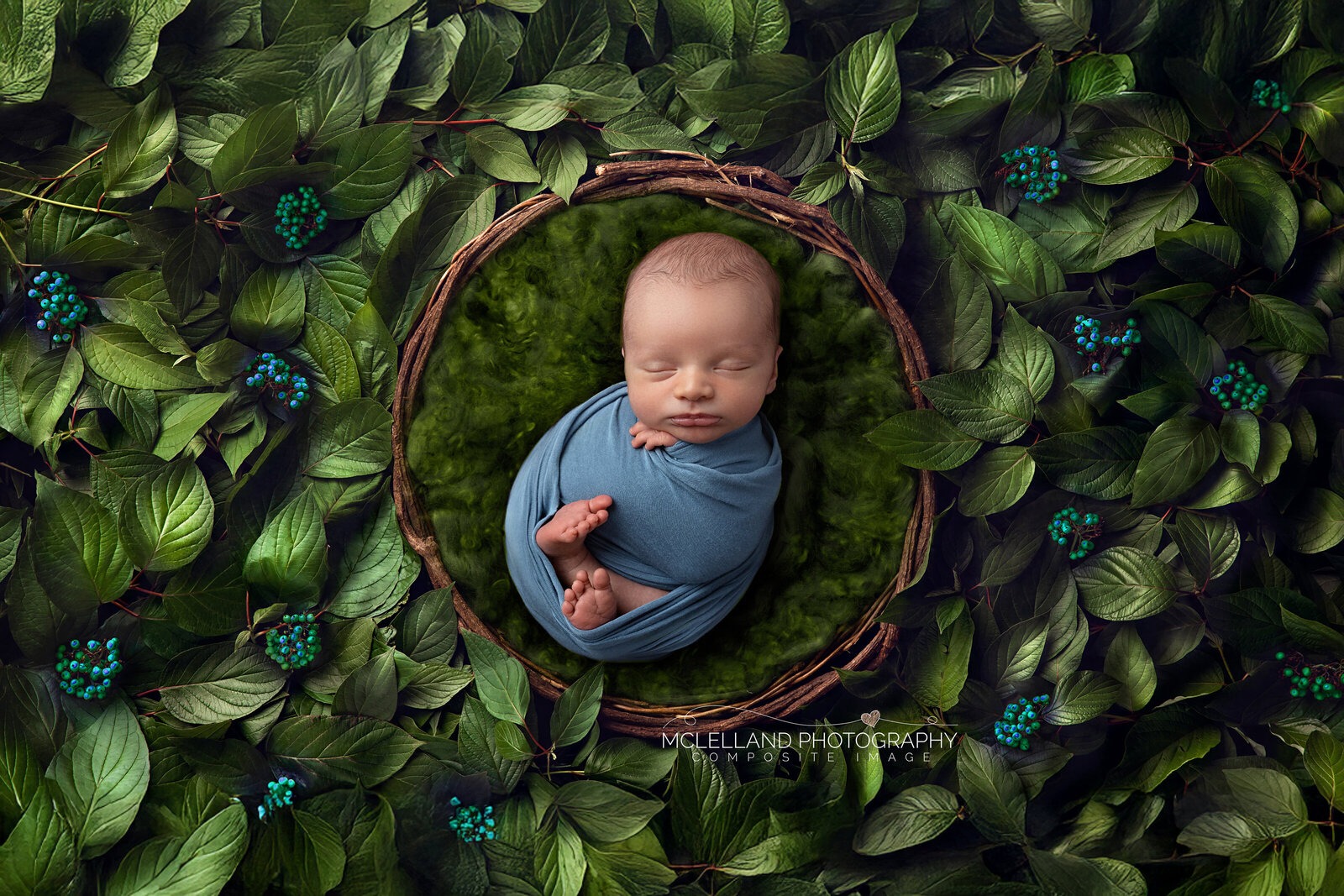 Sleeping newborn baby wrapped in blue in a forest-themed professional composite portrait