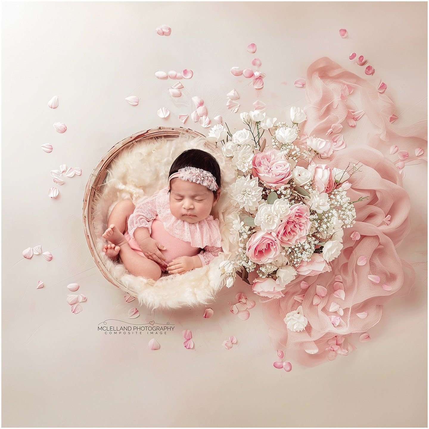 Sleeping newborn baby surrounded by pink and white flowers in a composite portrait