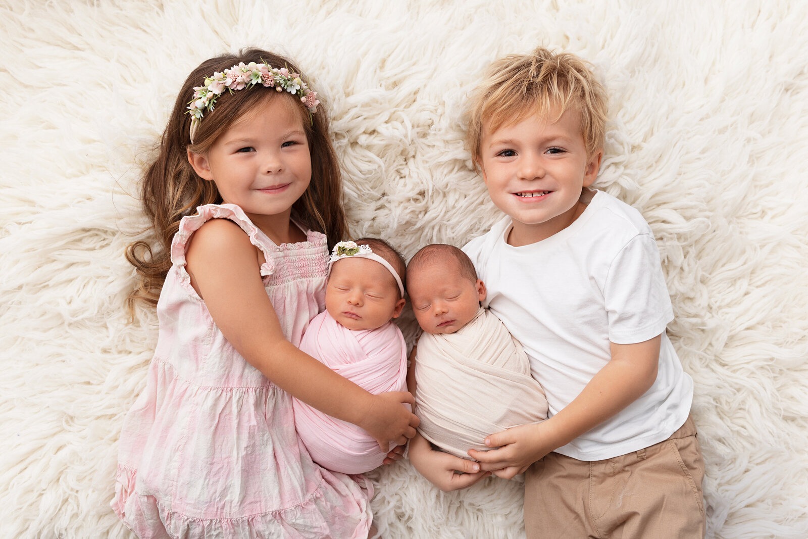 Professional newborn photography portrait of newborn twins with their older brother and sister